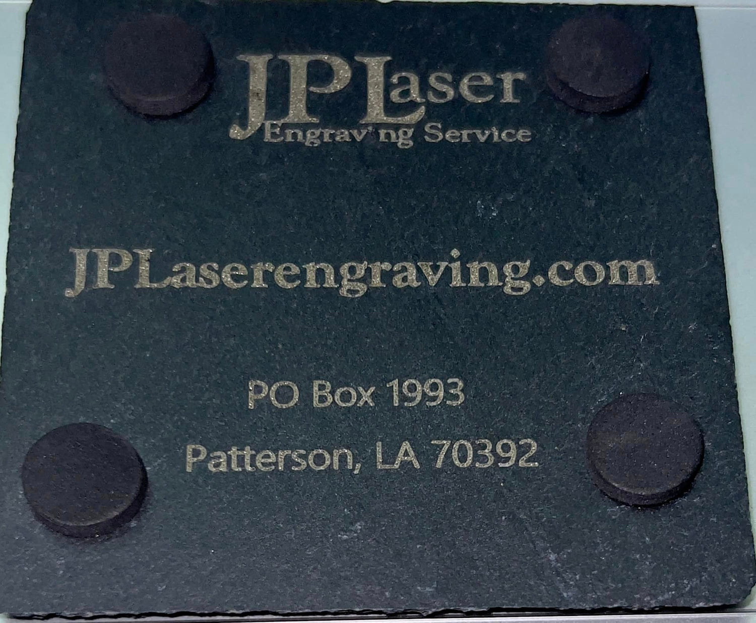 Rear of Black Slate Tile with JPLaser Engraving logo and contact info engraved on it.