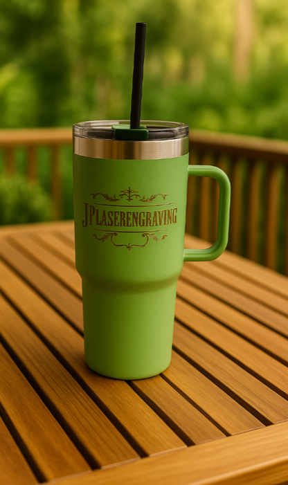 Green tumbler with straw on a wooden table outdoors