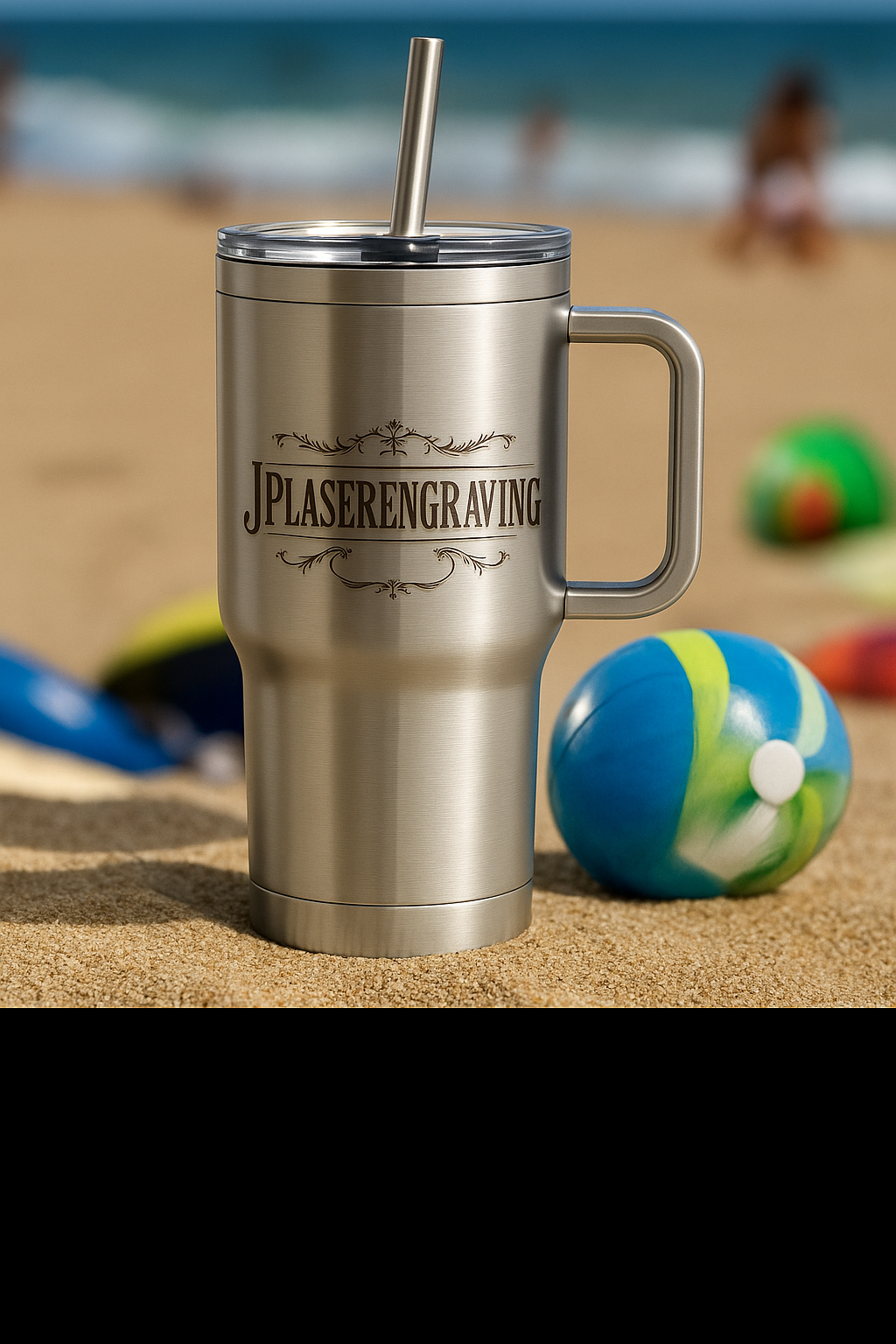 Stainless steel tumbler with handle on a sandy beach with beach balls and ocean in the background