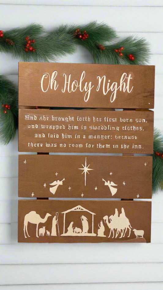a wooden slat hanging sign with the words from "Oh Holy Night" and the manger scene engraved on the bottom